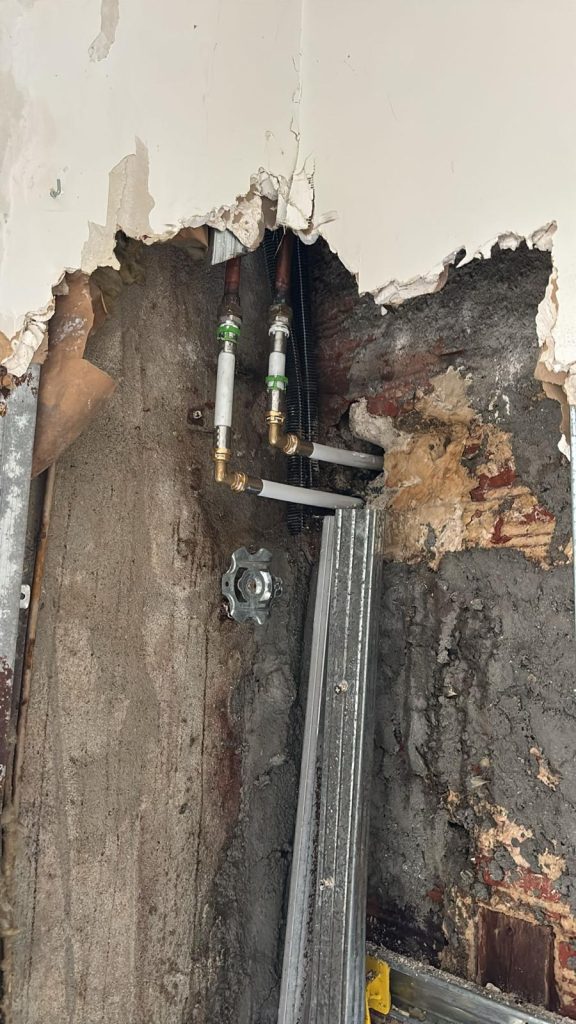 Tuyaux derrière un mur abîmé